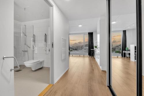 Un baño blanco con inodoro y lavabo. en TotalApartments Stakkevollvegen Studio, en Tromsø