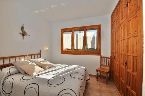 リョレート・デ・マルにあるVilla Victoriaのベッドルーム1室(ベッド1台、窓、木製キャビネット付)