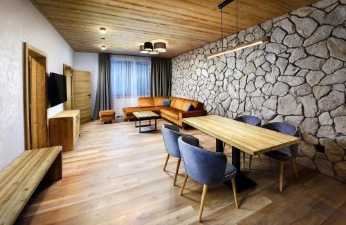 a room with a stone wall and a table and chairs at Apartmany Demänovka in Demanovska Dolina