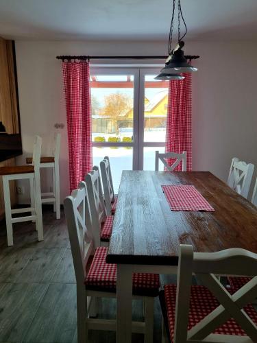 a dining room with a wooden table and chairs at Dům a chatka pod Smrkem in Nové Město pod Smrkem