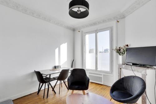 un soggiorno con tavolo e sedie di Appartement meublé quai de Seine a Ivry-sur-Seine