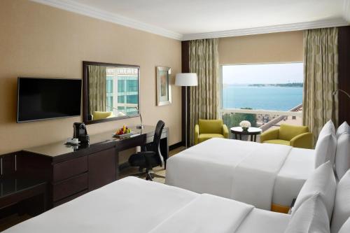 a hotel room with two beds and a television at Crowne Plaza Jeddah by IHG in Jeddah