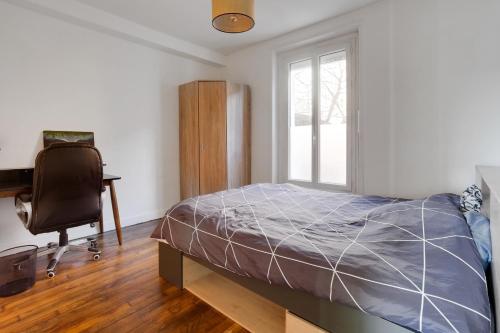 une chambre avec un lit, un bureau et une chaise dans l'établissement Appartement meublé quai de Seine, à Ivry-sur-Seine