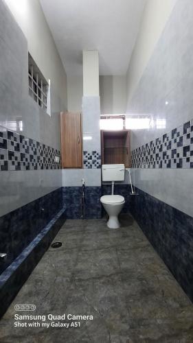 a bathroom with a toilet in a room at Varam Homestay in Madikeri