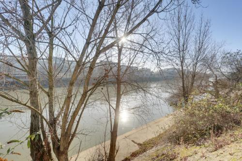 Un corpo d'acqua con il sole dietro alcuni alberi di Appartement meublé quai de Seine a Ivry-sur-Seine