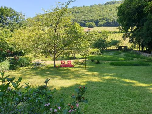 a garden with a red bench in the grass at Maison Bélénos in Nevy-sur-Seille
