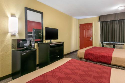 a hotel room with two beds and a flat screen tv at Econo Lodge Jonesboro in Jonesboro