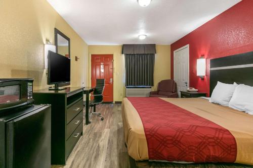 a hotel room with a bed and a flat screen tv at Econo Lodge Jonesboro in Jonesboro