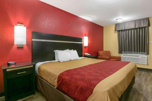 a hotel room with a bed and a red wall at Econo Lodge Jonesboro in Jonesboro