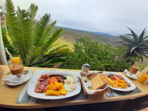 uma mesa com dois pratos de comida para o pequeno almoço em Pabala Private Nature Reserve em Hankey