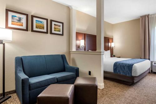 Habitación de hotel con cama y silla azul en Comfort Inn & Suites Junction City - near Fort Riley en Junction City