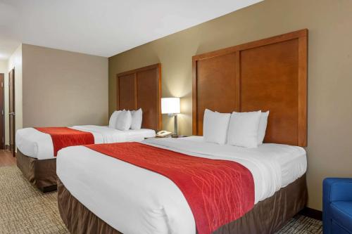 a hotel room with two beds and a blue chair at Comfort Inn Marion - West Memphis in Marion