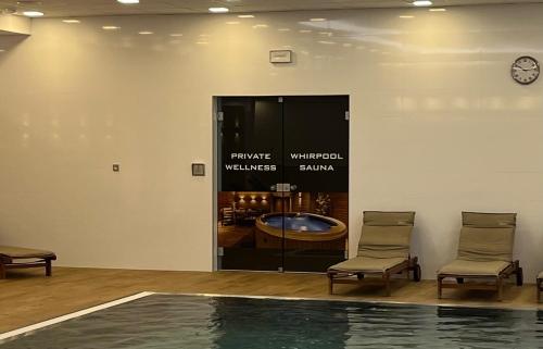 a room with two chairs and a table and a mirror at Moser Wellness Apartment Lux in Karlovy Vary
