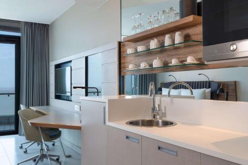 a kitchen with a sink and a table with chairs at Radisson Blu Hotel & Residence Maputo in Maputo