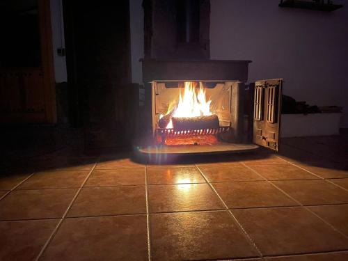 a fireplace with a fire in it in a room at Casa Rural El Carrizal in Riópar