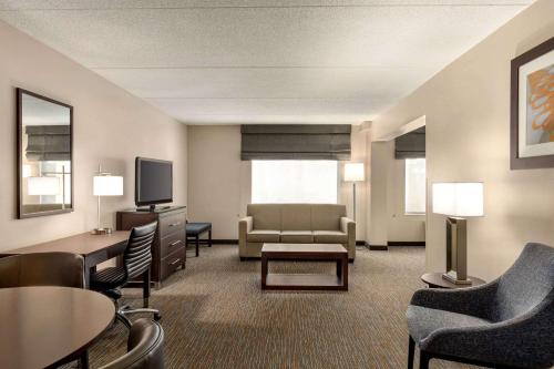 a living room with a couch and a tv at Wingate by Wyndham Wilmington in Wilmington