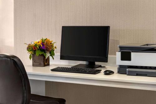 a desk with a computer monitor and a printer at Wingate by Wyndham Wilmington in Wilmington
