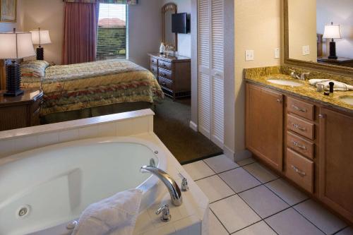 a bathroom with a tub and a bedroom with a bed at Vacation Villas 2, a Ramada by Wyndham in Kissimmee