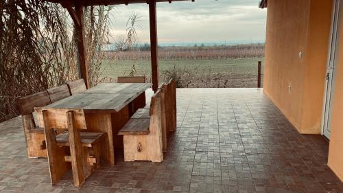 drewniany stół i ławki na patio w obiekcie KUĆA ZA ODMOR BRZICA ERDUT w mieście Erdut