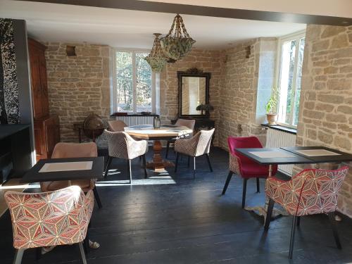a dining room with tables and chairs and brick walls at Maison Bélénos in Nevy-sur-Seille