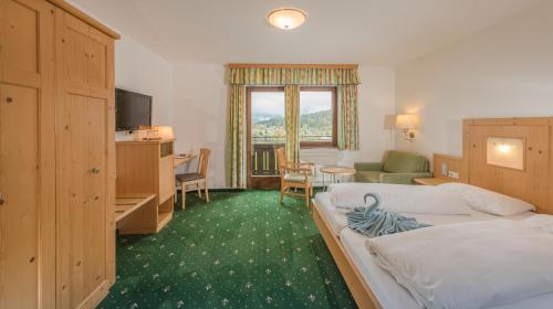 una camera d'albergo con un letto e una scrivania di Hotel Berghof a Ramsau am Dachstein