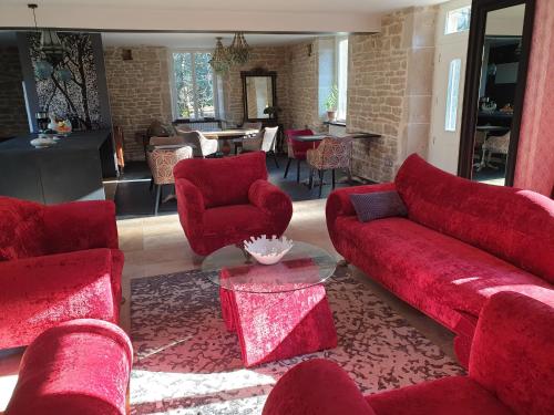 a living room with a red couch and chairs at Maison Bélénos in Nevy-sur-Seille