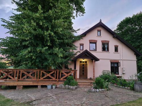 ein großes weißes Haus mit einem Holzzaun in der Unterkunft Swojski Gościniec in Prażmowo
