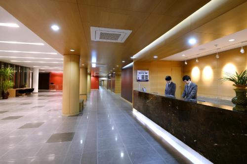 two men standing at a counter in a lobby at Jeju Aerospace Hotel in Seogwipo
