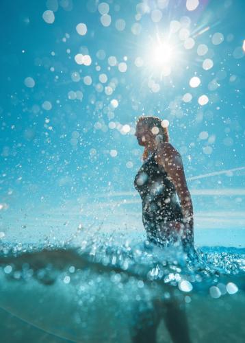 a person standing in the water with a dog at Ibis Hotel Alicante in Alicante
