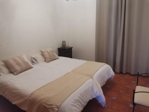 a bedroom with a large white bed in a room at Casa Cueva de los Verdes in Punta de Mujeres