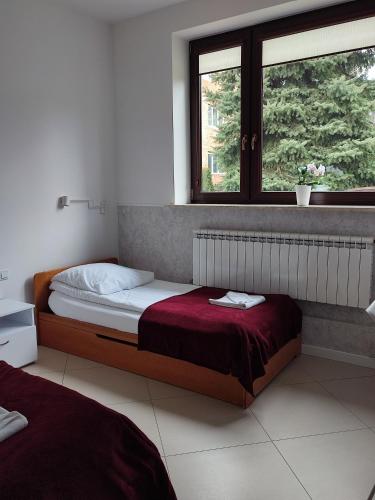 a bedroom with a bed and a window at WILLA BAJLAND in Warsaw