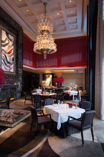 a restaurant with tables and chairs and a chandelier at The Peninsula Shanghai in Shanghai
