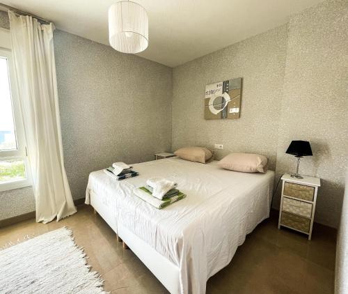 una camera da letto con un grande letto bianco e una finestra di Frontal Apartment First Line a Torrox Costa