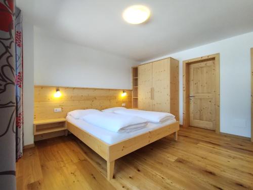 a bedroom with a bed and a wooden floor at Zimmererhof in Bressanone