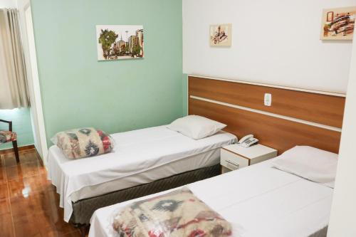 una habitación con 2 camas y un teléfono. en Hotel Jardim Sul, en São José dos Campos