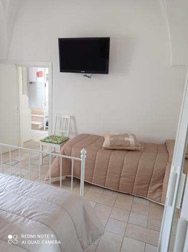 a living room with a bed and a flat screen tv at La loggetta 63 in Palagianello