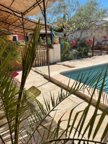 une maison avec une piscine dans une cour dans l'établissement Location saisonnière du Moulin, à Saint-Saturnin-les-Avignon