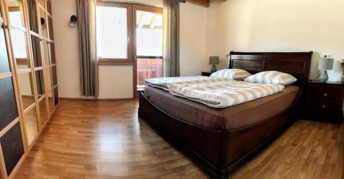 a bedroom with a large bed with a wooden floor at At the Potter’s House in Niederndorf