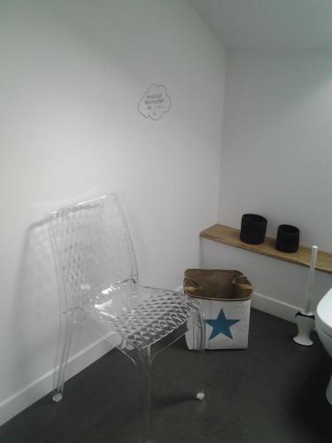 uma cadeira branca num quarto com uma estrela na parede em La Maison Mirabeau em Verdun-sur-Meuse