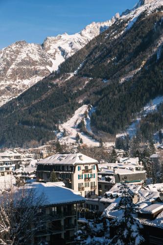 a view of a city with snow covered mountains at Chalet Hôtel Le Prieuré & Spa in Chamonix-Mont-Blanc