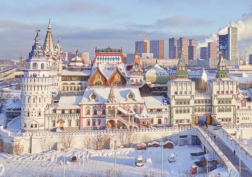 a large building covered in snow in front of a city at Izmailovo Delta Hotel in Moscow