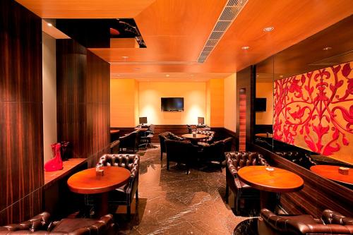 a restaurant with tables and chairs and a bar at Radisson Blu Hotel Chennai City Centre in Chennai
