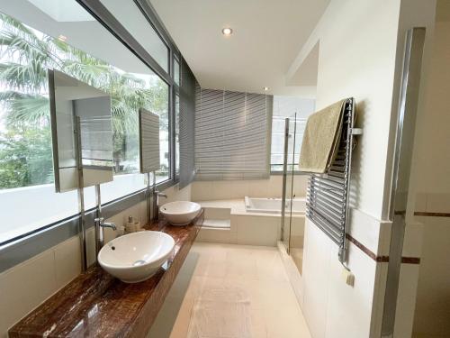 La salle de bains est pourvue de 2 lavabos et d'une grande fenêtre. dans l'établissement Modern villa in gated complex Sierra Blanca Marbella, à Marbella