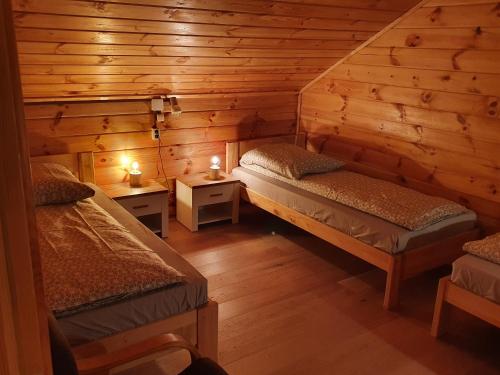 a room with two beds in a log cabin at Pod Mareszką in Krempna