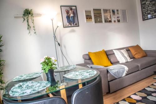 ein Wohnzimmer mit einem Sofa und einem Tisch in der Unterkunft Apartment Villeneuve Stade de France Free parking WiFi in Villeneuve-la-Garenne