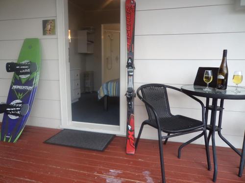 a table and a chair and a snowboard in a room at Tongariro Holiday Park in National Park