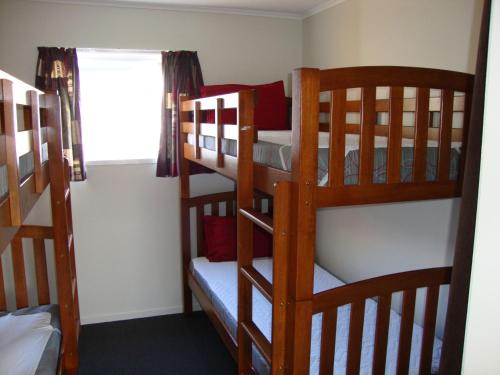 two bunk beds in a room with a window at Tongariro Holiday Park in National Park