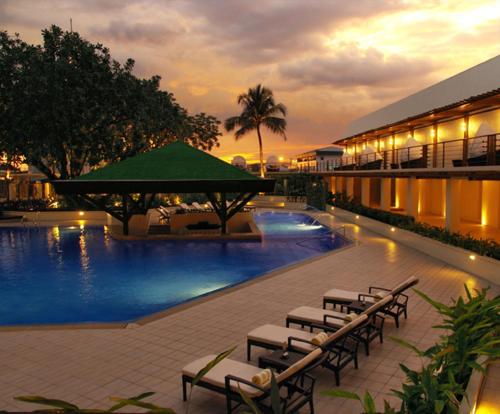 a swimming pool with chairs and a hotel at The Manila Hotel in Manila