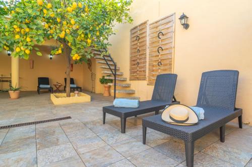 a patio with two chairs and an orange tree at Juniper -Inca- in Inca