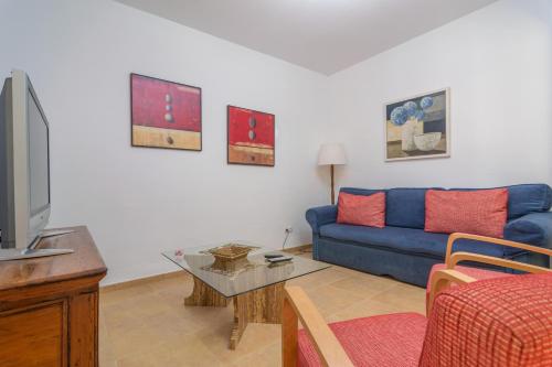a living room with a blue couch and a tv at Juniper -Inca- in Inca